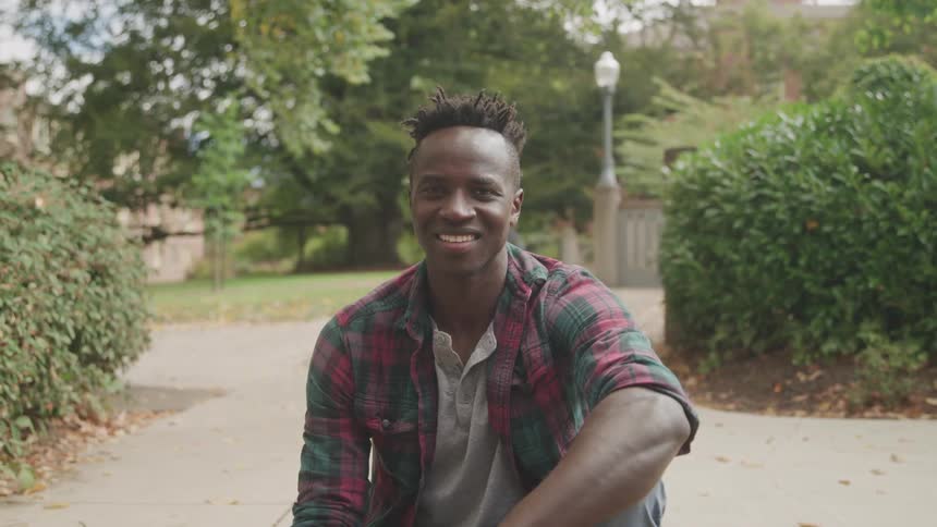 Man sitting outdoors with a smile on his face