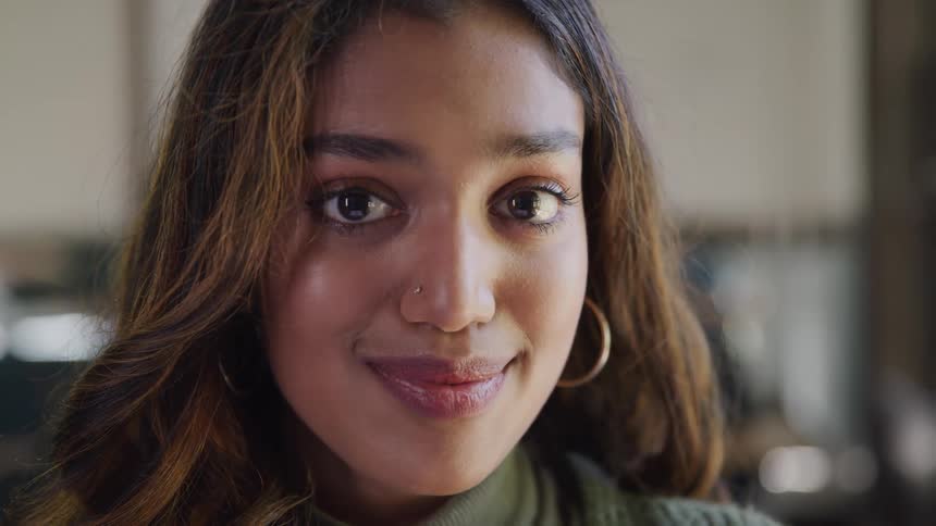 Closeup portrait of a womans face her gaze is directed to the front her dark brown hair frames her face
