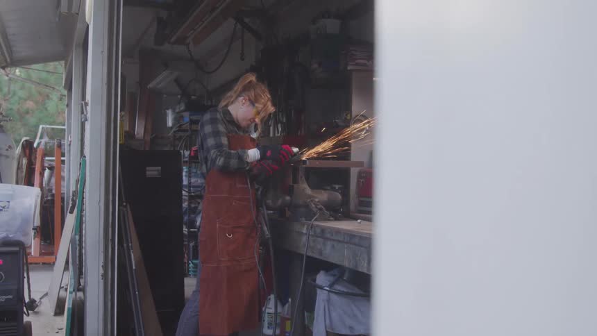 Woman using a welding tool in a workshop