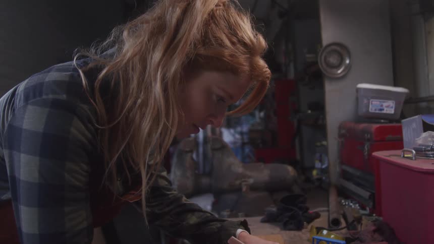 Woman uses a pencil on the table in a workshop