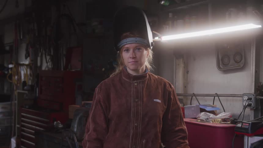 Woman with an open protective mask in a workshop