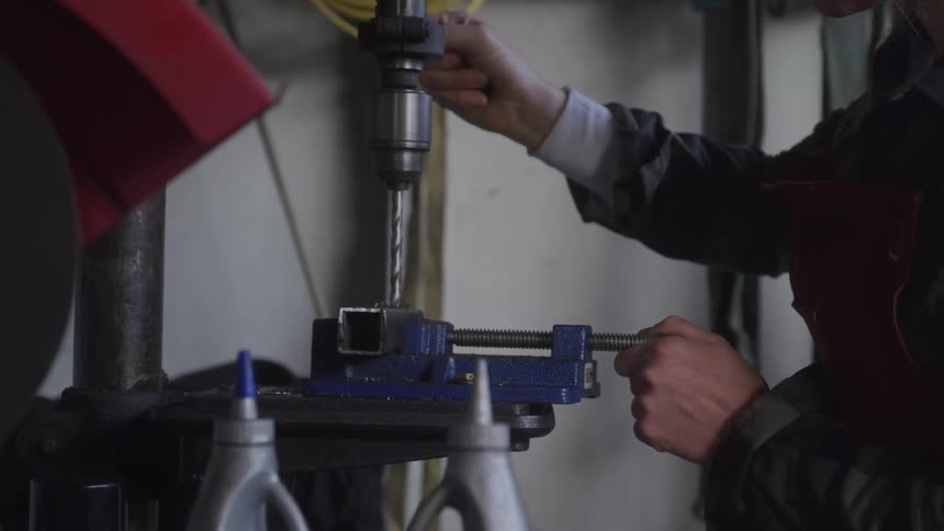 Machinist lowers and raises the drill press