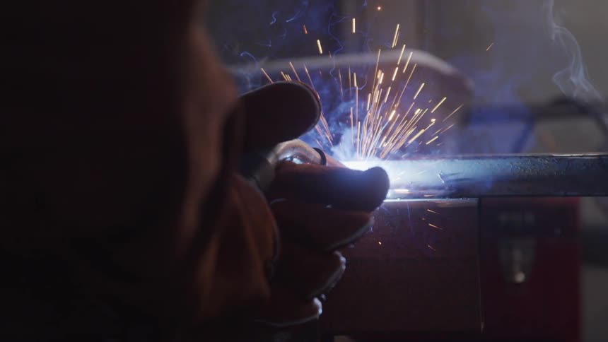 Hand with gloves welding a metal