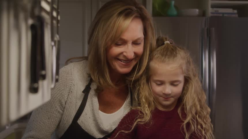 Mother and daughter happily together in the kitchen