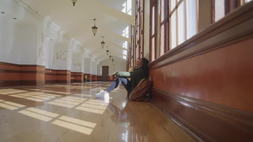 Woman sitting on the floor in the hallway of a building