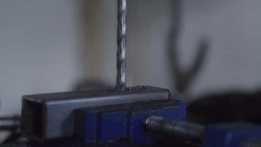 Closeup of a drill bit drilling into a metal surface