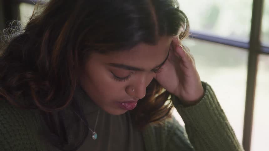 Woman in an indoor environment with a concentrated expression