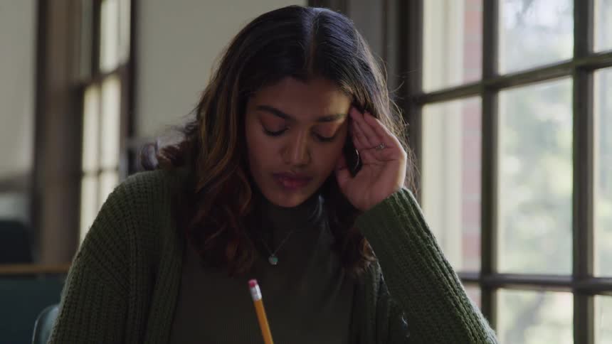 Woman sitting and writing with a pencil