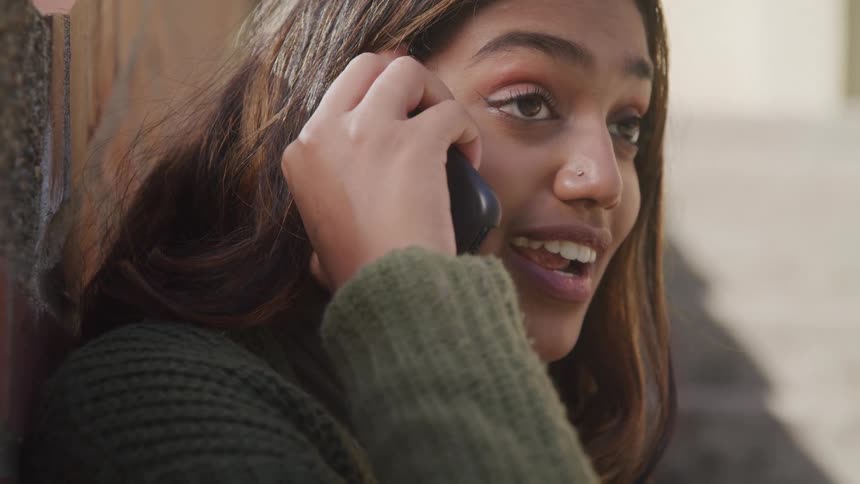 The woman smiles while using her cell phone