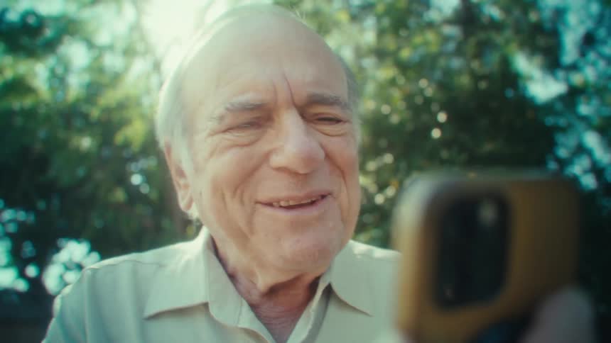 Man smiles and walks during a video call on his smart phone