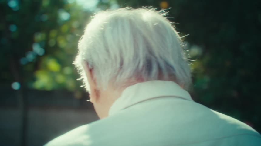 Elderly man talks and walks in his backyard