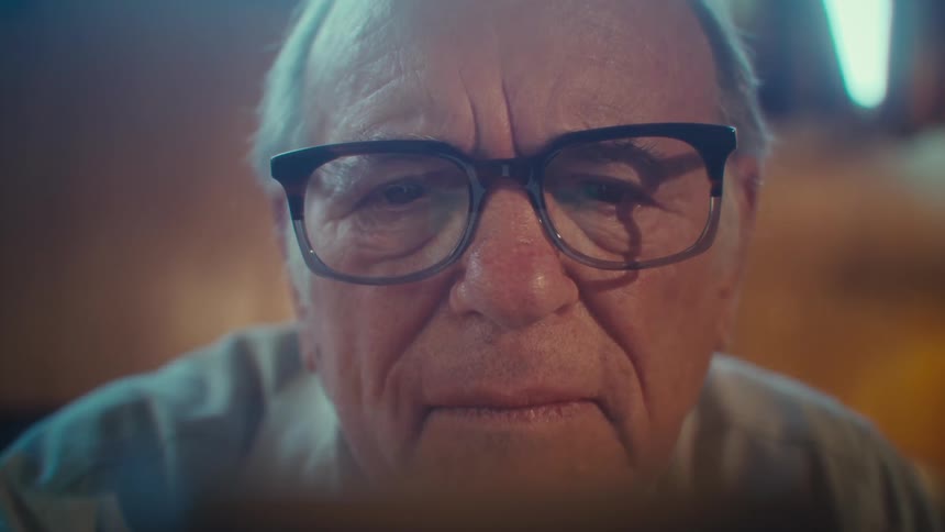 Elderly man with a happy expression and interacting with a smartphone