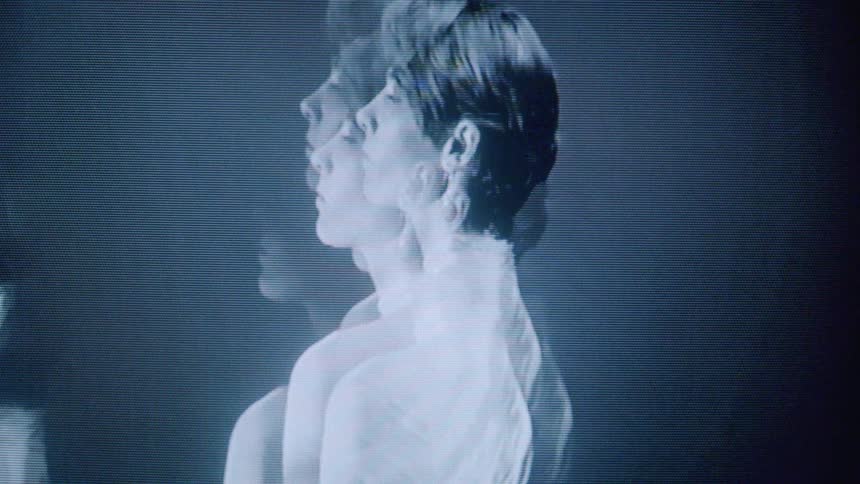 The model poses slowly as her image is mirrored