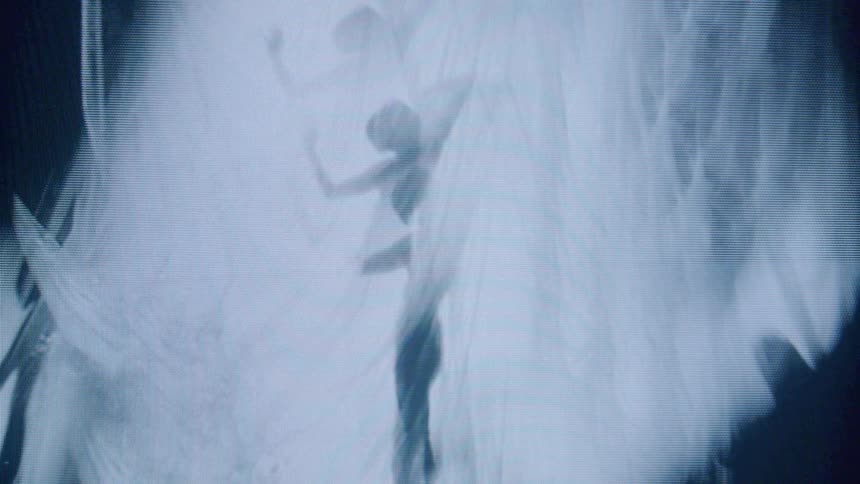 The video features a monochrome pixelated visual of a persons silhouette with light blue and white hues appearing to be dancing or moving rhythmically the figure is semitransparent and appears to be in motion against a backdrop that resembles a mist