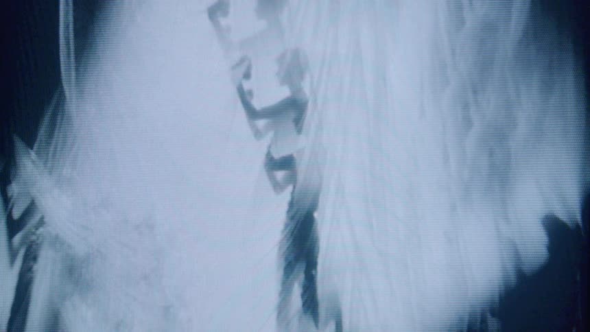 A stylized monochrome image shows a climber scaling a vertical wall or cliff viewed through a pixelated or crtstyle screen with visible scan lines and distortion