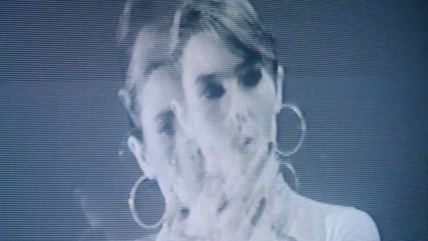 The video displays an abstract monochromatic black and white closeup of a persons face with a pixelated or grainy effect giving it a somewhat digital or vintage television appearance the face is predominantly shown in profile but occasionally