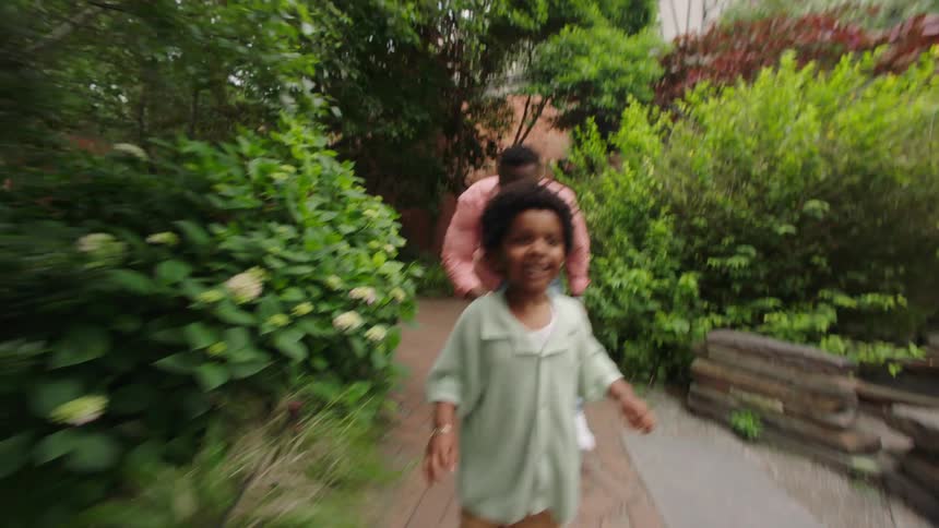 The video shows an older man with grey hair wearing a lightcolored shirt using a smartphone outdoors with a blurred background of green foliage he appears to be relaxed and focused on his device