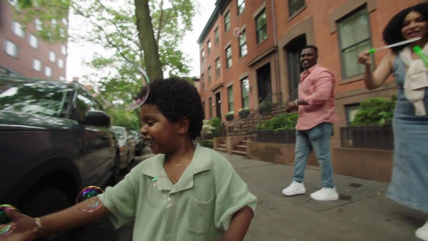 A child chases after the bubbles outside of his home