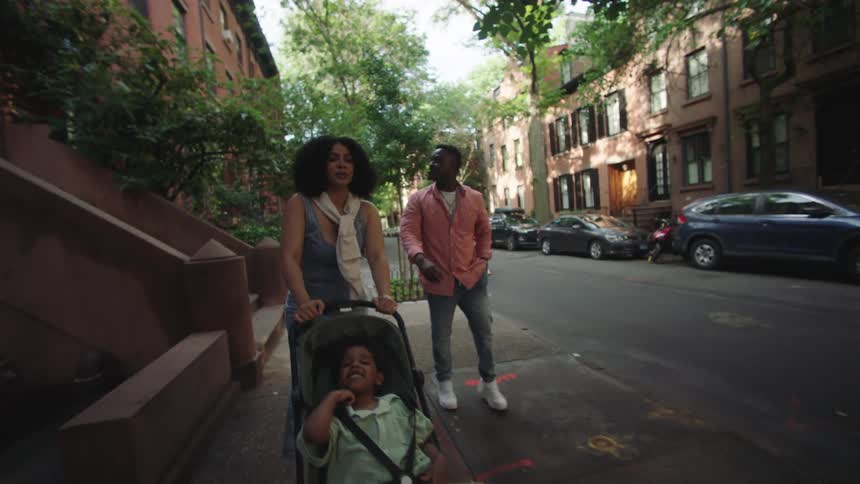 A family walk together on the sidewalk