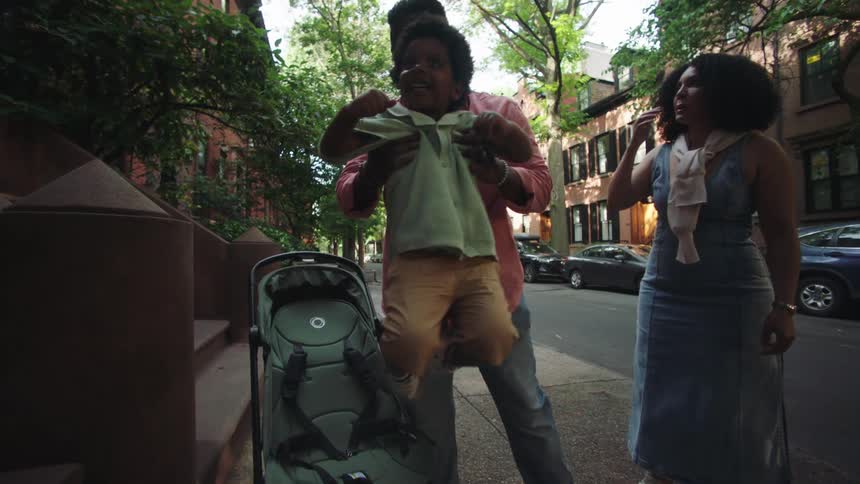 A father lifts his son into the stroller
