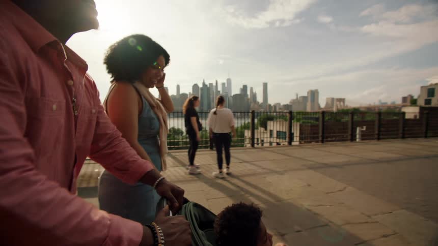Family walks with stroller along city waterfront at sunset