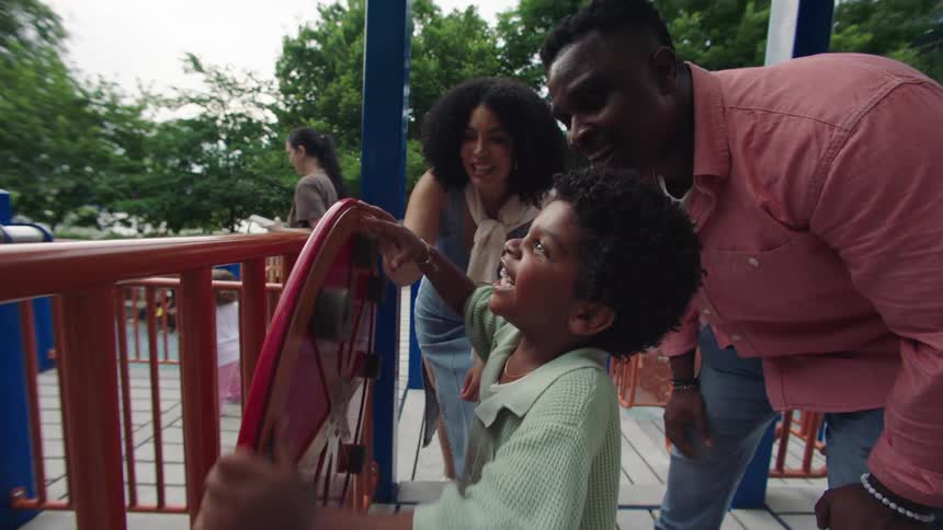 Father and mother in an outdoor park playing with their son