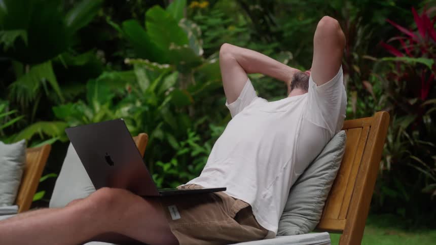 Man celebrates a successful remote work achievement while relaxing outdoors