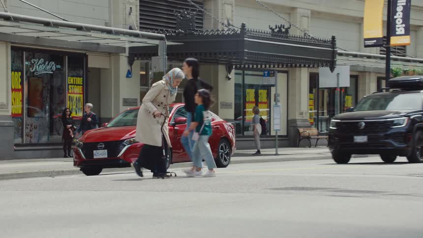 Elderly woman crossing the street in an urban area with vehicle traffic