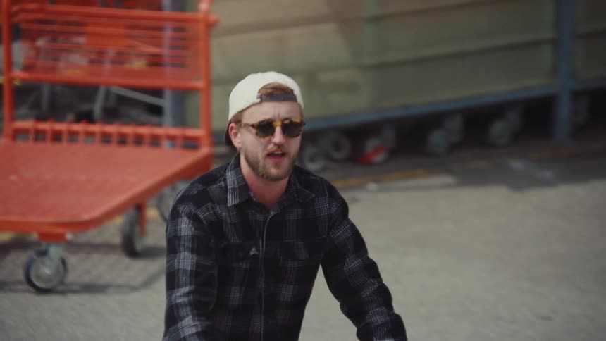 The customer pushes his shopping cart in the parking lot