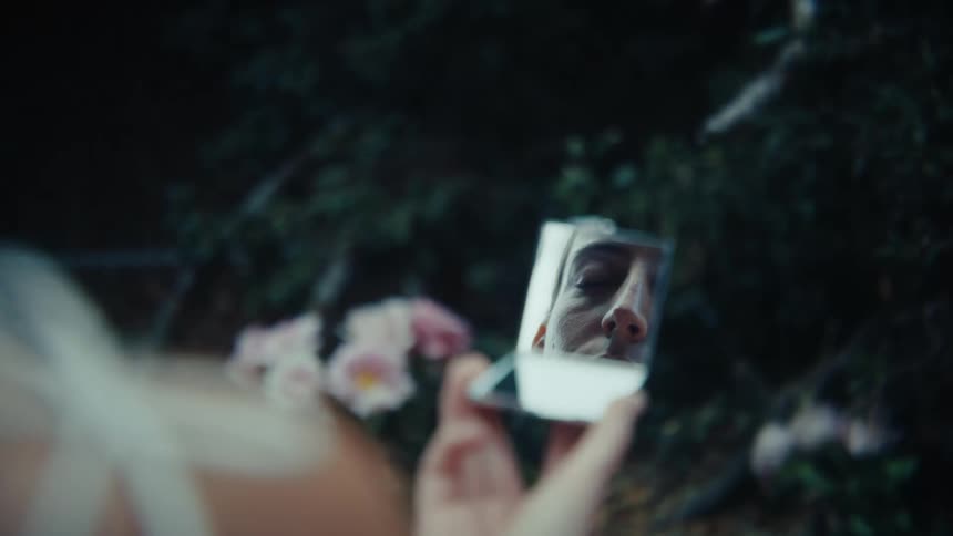 The womans face is reflected in the mirror