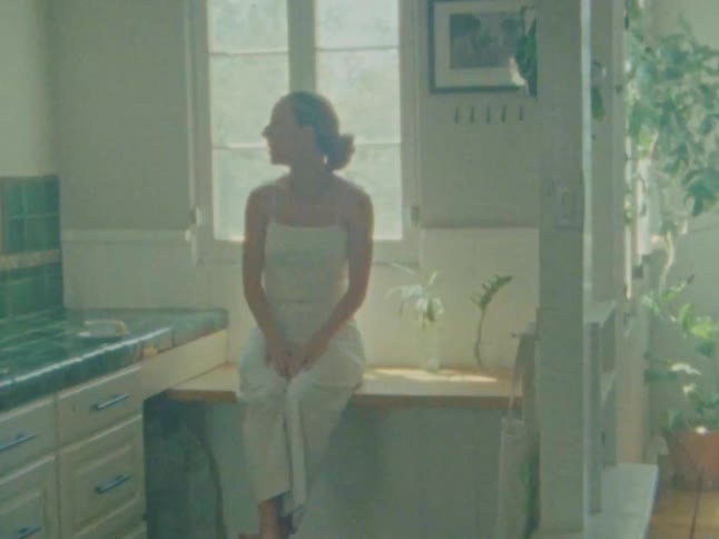Woman sitting on a wooden stand in the kitchen