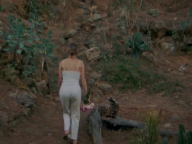 The woman begins climbing the hill
