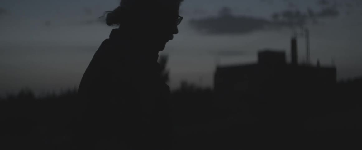 A man walks outdoors at dusk