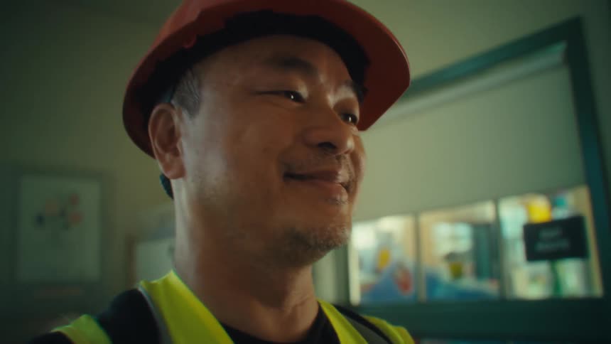 The worker smiles while checking the tablet