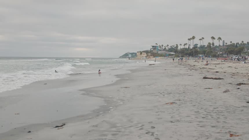 Panorama of a beach with bathers on a cloudy day