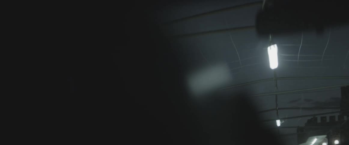 A vehicle drives beneath fluorescent lights at night