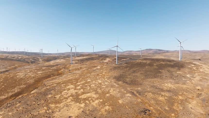 Panorama of a field with reliefs and wind turbines in operation