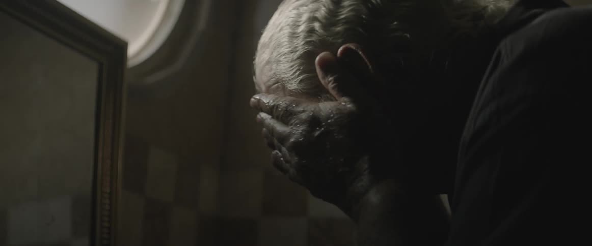An older man rubbing and washing his face in a bathroom