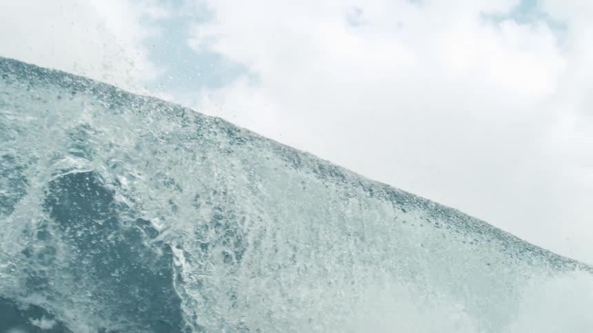 A giant wave crashes as the camera goes underwater in a big blur