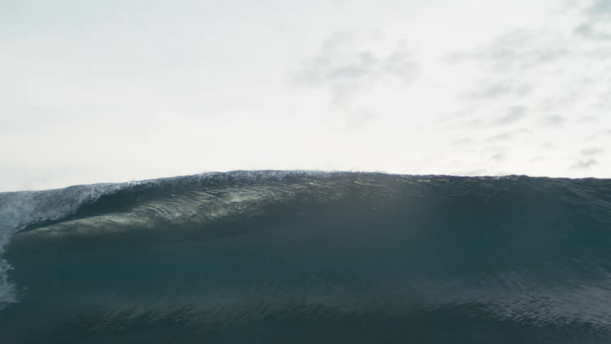 Wave forming in the sea under a cloudy sky