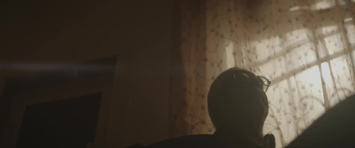 A man looks up in a dark room