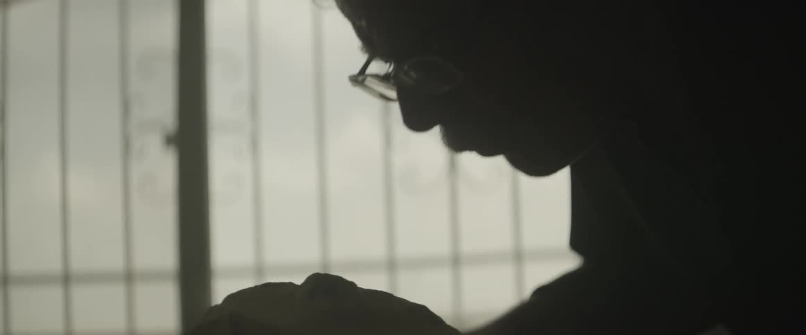 A man blows dust from a rock