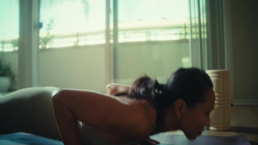 A young woman doing pushups indoors