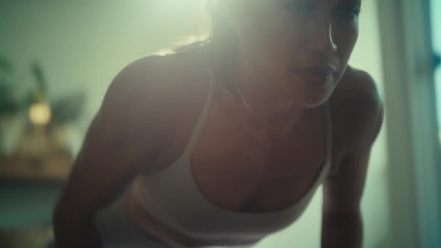 Woman does a set of push ups in her living room
