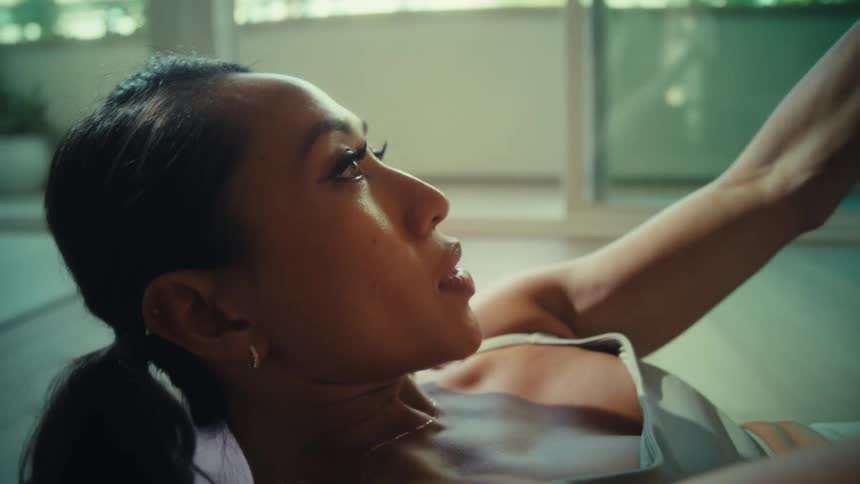 A woman is working out on the floor with focused determination
