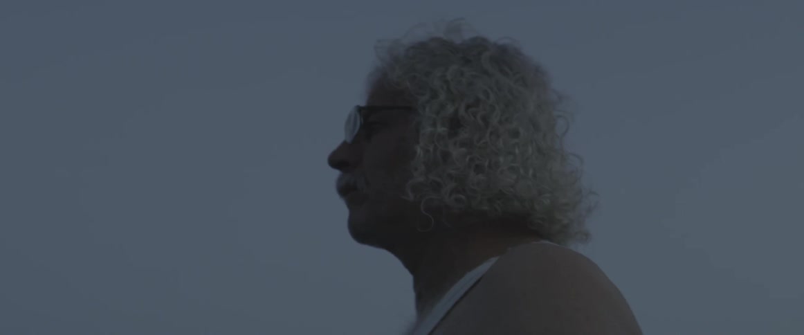 An elderly man looks out into the distance