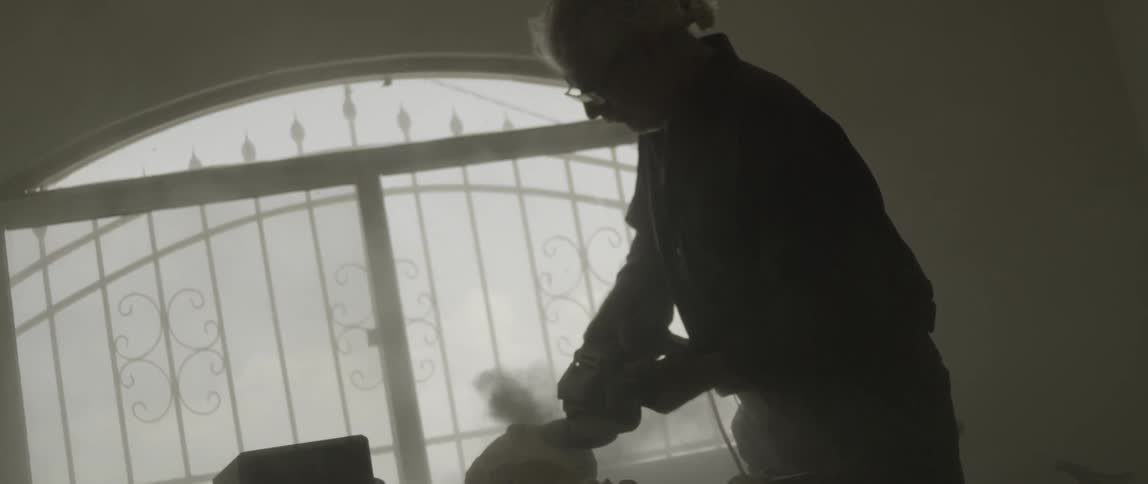 A man carves a chunk of wood