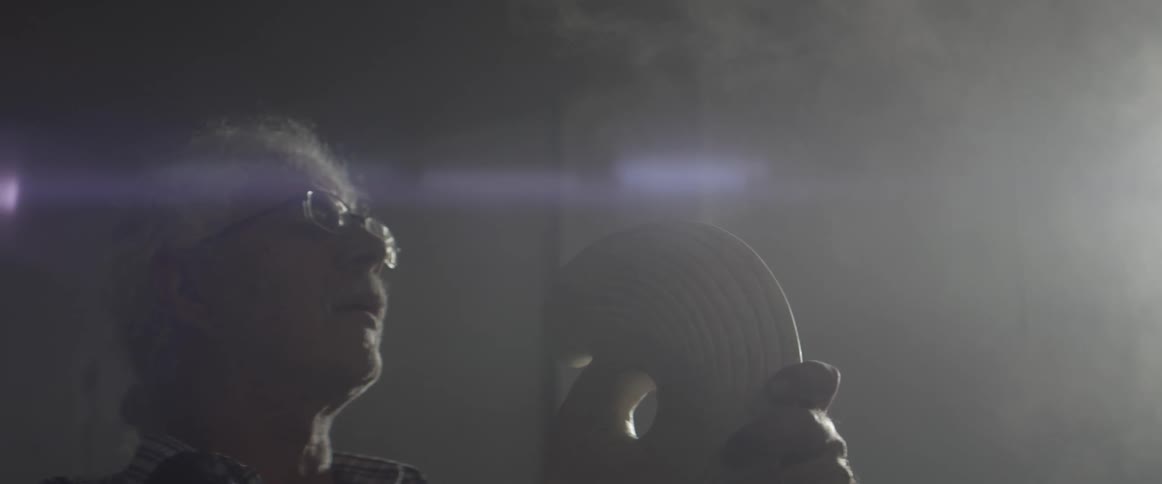 Man blowing dust off of a sculpture