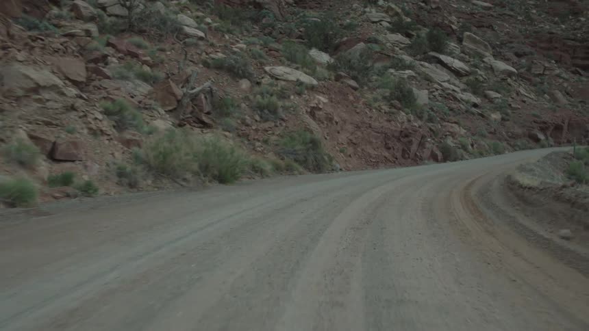 Vehicle drives on the dirt road in the mountains