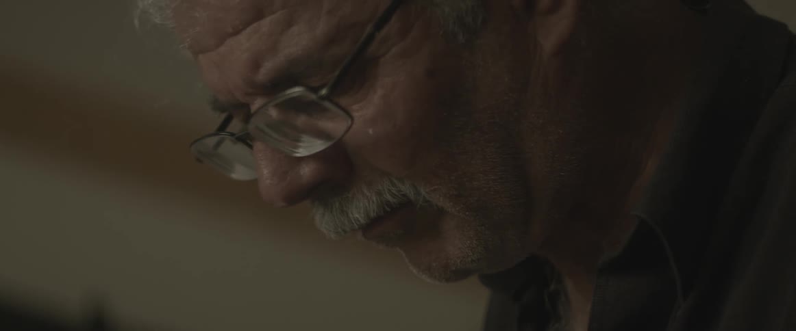 Man staring downward in a room indoors